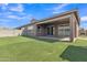 Green backyard featuring artificial turf, brick patio, and the home's covered patio area at 1900 N 140Th Dr, Goodyear, AZ 85395