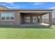 Manicured backyard with synthetic grass, patio, and a covered patio space great for outdoor relaxation at 1900 N 140Th Dr, Goodyear, AZ 85395