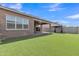 Green backyard with artificial turf and covered patio, ready for relaxation and recreation at 1900 N 140Th Dr, Goodyear, AZ 85395