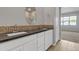 Bathroom vanity with black countertop and designer backsplash at 1900 N 140Th Dr, Goodyear, AZ 85395