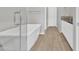 Bright bathroom with a freestanding tub with glass door and neutral tile at 1900 N 140Th Dr, Goodyear, AZ 85395