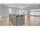Open-concept kitchen features a large island, wood flooring, and slider door to the backyard at 1900 N 140Th Dr, Goodyear, AZ 85395