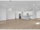 Spacious open-concept living area showcasing a kitchen island and light-colored tile flooring throughout at 1900 N 140Th Dr, Goodyear, AZ 85395