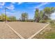 Community sand volleyball court with mature trees and lighting at 1900 N 140Th Dr, Goodyear, AZ 85395