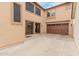 An exterior view of the home with a spacious concrete patio and an attached two-car garage at 19043 E Seagull Dr, Queen Creek, AZ 85142