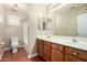 Bathroom with double sinks, white countertop, wood cabinets, and separate toilet and shower at 23063 W Loma Linda Blvd, Buckeye, AZ 85326