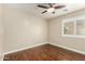 Bedroom with wood floors, neutral walls and window with white plantation shutters at 23063 W Loma Linda Blvd, Buckeye, AZ 85326