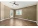 Well-lit bedroom features a ceiling fan, tiled floor, and shuttered window, complemented by a door to the backyard at 23063 W Loma Linda Blvd, Buckeye, AZ 85326