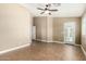 Bedroom with a ceiling fan and tile floors, featuring a door leading to the outside and shutters on the windows at 23063 W Loma Linda Blvd, Buckeye, AZ 85326