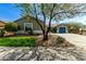 Charming single-story home with a well-manicured front yard and vibrant desert landscaping under a clear blue sky at 23063 W Loma Linda Blvd, Buckeye, AZ 85326