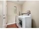 Laundry room with white washer and dryer, and overhead shelf for supplies at 23063 W Loma Linda Blvd, Buckeye, AZ 85326