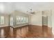 Spacious living room featuring hardwood floors, ceiling fan, and abundant natural light from large windows at 23063 W Loma Linda Blvd, Buckeye, AZ 85326