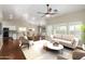 Bright living room featuring hardwood floors, neutral decor, modern furniture, and large windows with natural light at 23063 W Loma Linda Blvd, Buckeye, AZ 85326