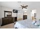 Primary bedroom with a ceiling fan, a decorative mirror and access to Primary bathroom at 2452 W Muirfield Dr, Anthem, AZ 85086