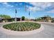 Attractive community entrance with flag poles and colorful floral landscaping at 2452 W Muirfield Dr, Anthem, AZ 85086