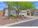 Inviting single-story home with desert landscaping, large tree, and a two-car garage at 2452 W Muirfield Dr, Anthem, AZ 85086