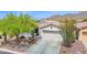 Charming desert home with well-maintained landscaping, a two-car garage, and a welcoming entrance at 2452 W Muirfield Dr, Anthem, AZ 85086