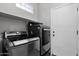 Well-equipped laundry room featuring modern washer and dryer units, and ample storage space at 2452 W Muirfield Dr, Anthem, AZ 85086