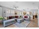 Spacious living room featuring plush seating, ceiling fans, and seamless flow to the kitchen at 2452 W Muirfield Dr, Anthem, AZ 85086