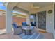 Inviting covered patio with comfortable seating, ceiling fan, and sliding glass door to the indoors at 2452 W Muirfield Dr, Anthem, AZ 85086