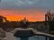 A gorgeous sunset view over the pool with a stylish table set for outdoor enjoyment at 2452 W Muirfield Dr, Anthem, AZ 85086