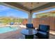 Inviting covered pool patio with comfortable seating, perfect for outdoor relaxation and entertaining at 2452 W Muirfield Dr, Anthem, AZ 85086