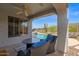 Inviting covered pool patio with comfortable seating, with a view of the pool and desert landscape at 2452 W Muirfield Dr, Anthem, AZ 85086