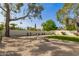 Expansive backyard with gravel, artificial turf, privacy wall, and scenic tree views at 2517 E Sahuaro Dr, Phoenix, AZ 85028