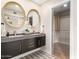 Elegant bathroom showcasing a double sink vanity with gold framed mirrors and a modern closet at 2517 E Sahuaro Dr, Phoenix, AZ 85028