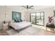Bright, modern bedroom featuring a large bed, ceiling fan, artwork, and a sliding glass door to the outside at 2517 E Sahuaro Dr, Phoenix, AZ 85028