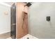 Walk-in shower with stone floor, rainfall showerhead and decorative shower niche in this bright and airy bathroom at 2517 E Sahuaro Dr, Phoenix, AZ 85028