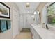Bright bathroom with double sinks, quartz counters, framed mirrors, and a walk-in shower at 252 E Orange Dr, Phoenix, AZ 85012
