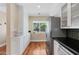 Galley kitchen with stainless appliances, custom white cabinets and black countertops at 252 E Orange Dr, Phoenix, AZ 85012