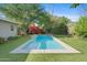 Inviting backyard pool surrounded by green turf and lush landscaping at 252 E Orange Dr, Phoenix, AZ 85012