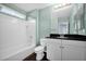 Well-lit bathroom with white tile, vanity with a black countertop, and modern fixtures at 2534 N 73Rd Dr, Phoenix, AZ 85035