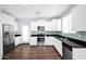 Modern kitchen with white cabinetry, stainless steel appliances, and a mosaic tile backsplash at 2534 N 73Rd Dr, Phoenix, AZ 85035