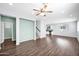 Open-concept living room with hardwood floors, a ceiling fan, and access to the dining area and kitchen at 2534 N 73Rd Dr, Phoenix, AZ 85035