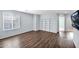 Spacious living room with wood-look floors, a large window, and modern decor and mounted television at 2534 N 73Rd Dr, Phoenix, AZ 85035