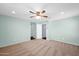 Empty bedroom showcasing a ceiling fan, two entryways, and two large windows offering ample natural light at 2534 N 73Rd Dr, Phoenix, AZ 85035