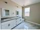 Modern bathroom featuring a double sink vanity, bright window, and sleek marble tile flooring at 25745 W Peak View Rd, Wittmann, AZ 85361