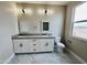 Modern bathroom featuring a double sink vanity, bright window, and sleek marble tile flooring at 25745 W Peak View Rd, Wittmann, AZ 85361