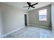 Light-filled bedroom features gray tile, a window, ceiling fan, and a walk-in closet at 25745 W Peak View Rd, Wittmann, AZ 85361