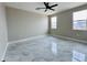 Large bedroom features light gray tile flooring, multiple windows, and a ceiling fan at 25745 W Peak View Rd, Wittmann, AZ 85361