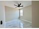 Bright bedroom featuring a contemporary ceiling fan, bright window and sleek marble tile flooring at 25745 W Peak View Rd, Wittmann, AZ 85361