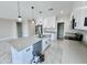 Bright kitchen with white cabinets, gray countertops, a kitchen island with a sink, and marble-style tile flooring at 25745 W Peak View Rd, Wittmann, AZ 85361