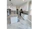 Modern kitchen showcasing white cabinetry, a gray countertop island, and stainless steel appliances at 25745 W Peak View Rd, Wittmann, AZ 85361
