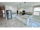 Well-lit kitchen featuring white cabinetry, gray countertops, a kitchen island with a sink, and stainless steel appliances at 25745 W Peak View Rd, Wittmann, AZ 85361