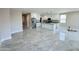 Open-concept living space featuring a kitchen with white cabinets, island, and marble-style tile flooring at 25745 W Peak View Rd, Wittmann, AZ 85361