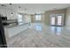 Open-concept living and kitchen area featuring white cabinetry, an island, and marble-style flooring throughout at 25745 W Peak View Rd, Wittmann, AZ 85361