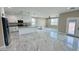 Spacious living area with a combined kitchen featuring white cabinets, a central island, and marble-style flooring at 25745 W Peak View Rd, Wittmann, AZ 85361